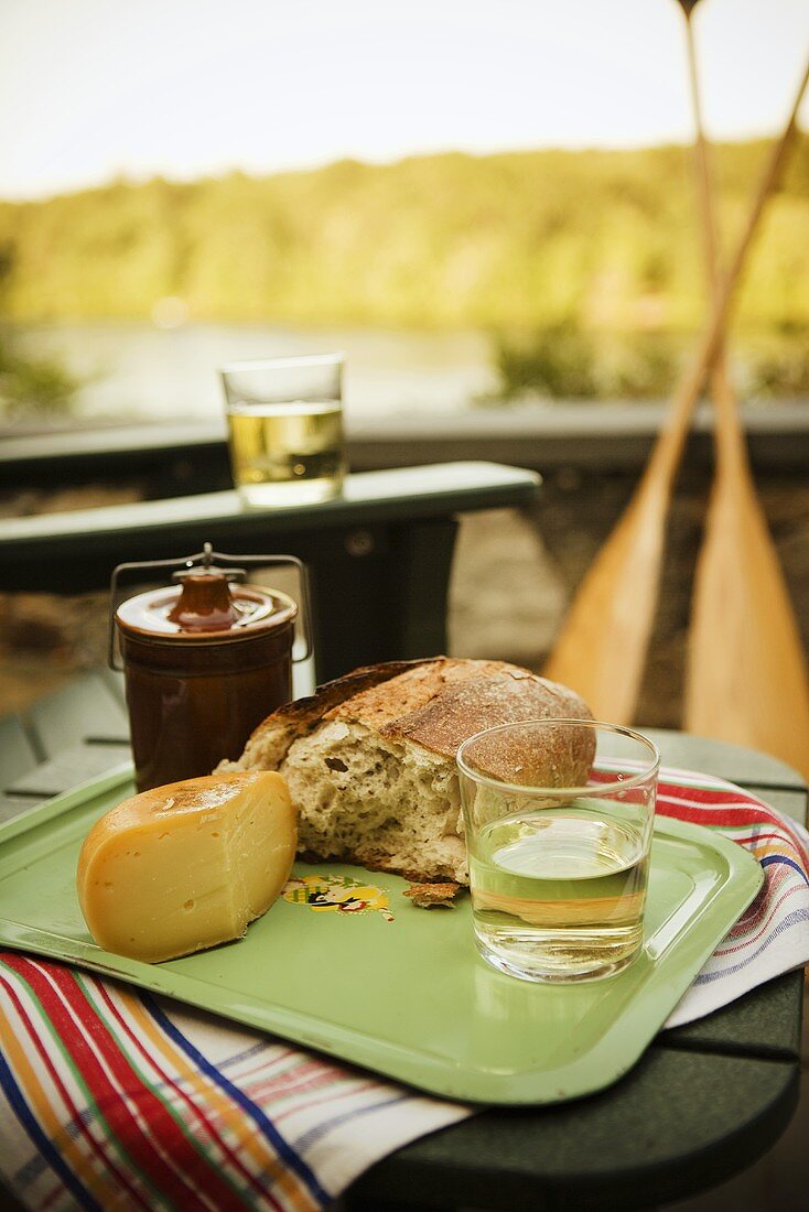 Picknick am See mit Brot, Käse und Wein