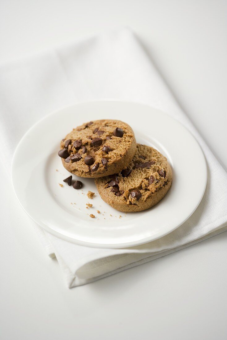 Two Chocolate Chip Cookies on a White Plate
