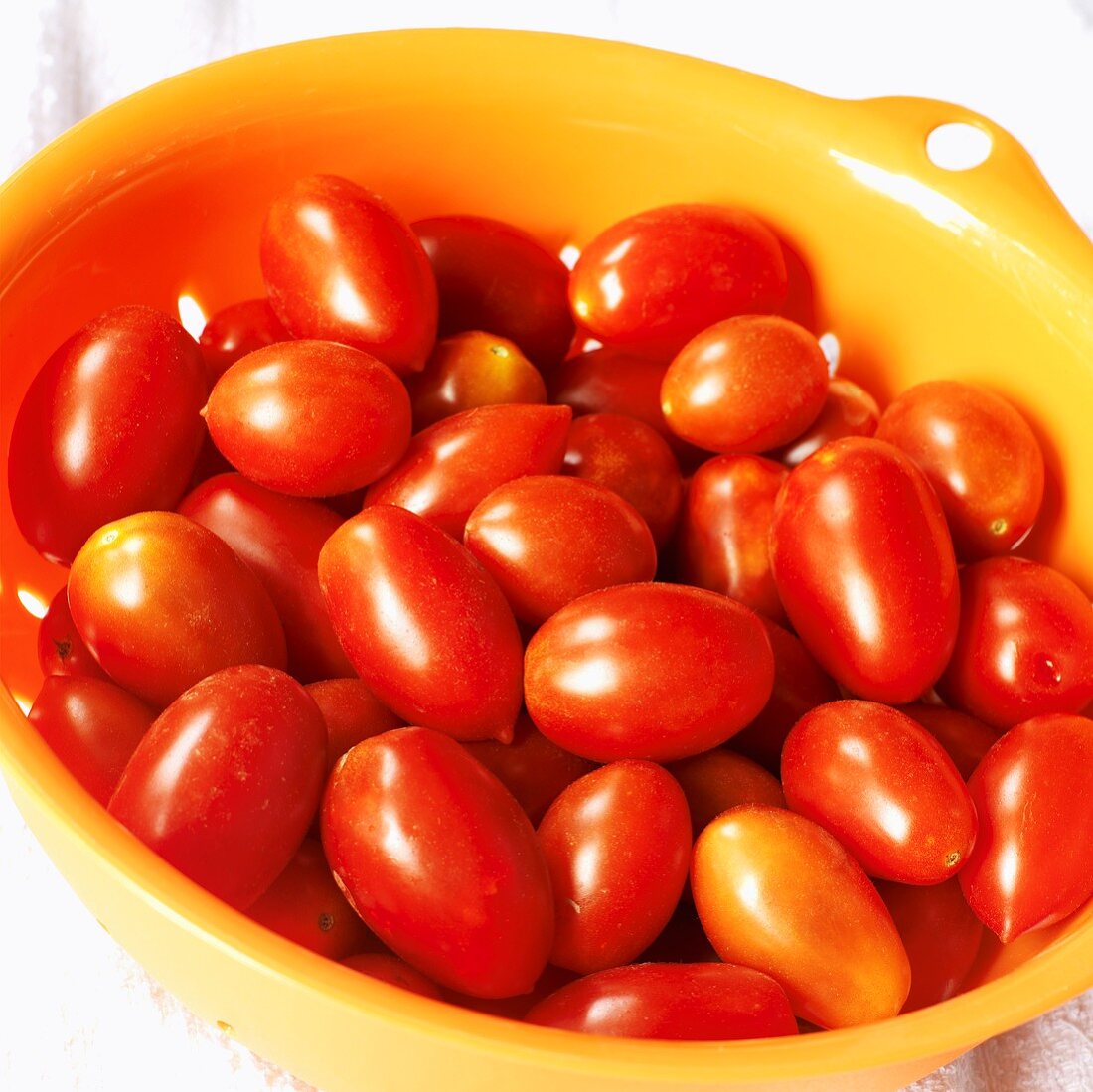 Viele Tomaten (Sorte Juliet) im Plastiksieb