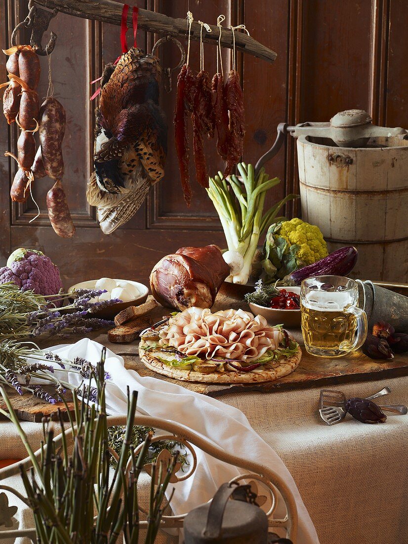 Rustikales Buffet mit Schinken, Wurst, Fasan, Bier und Gemüse