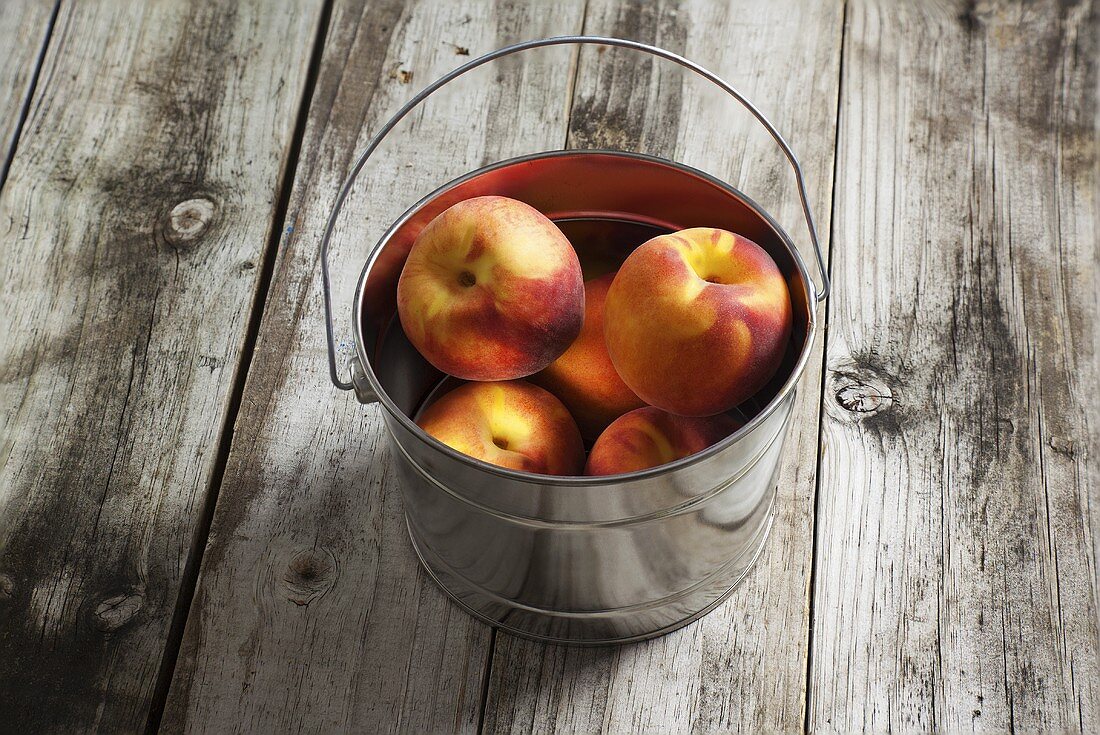 Ripe Peaches in a Tin Bucket on Rustic Wooden Table