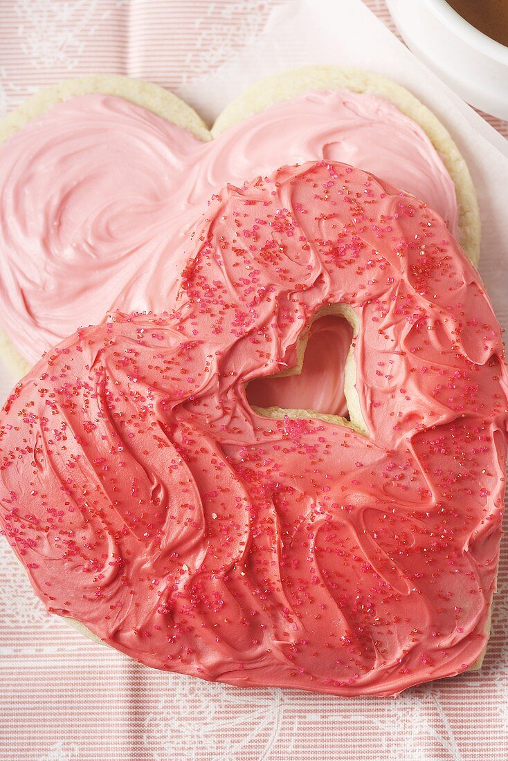 Herzplätzchen mit rosa Glasur und Zuckerstreuseln