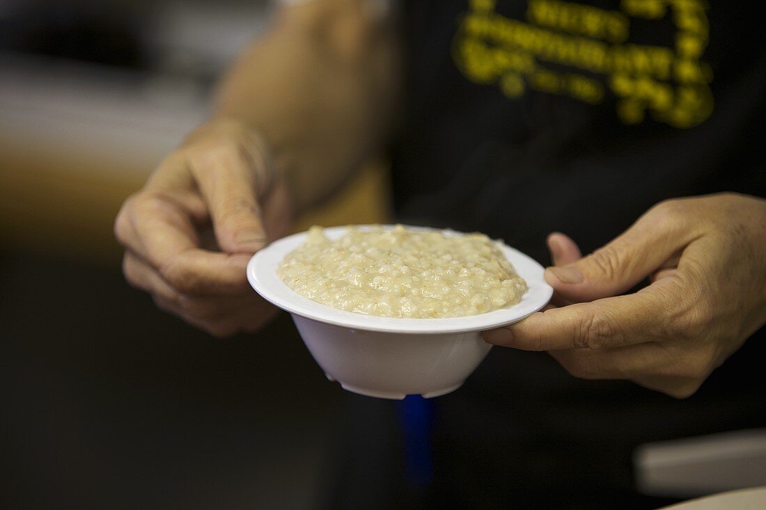 Man Carrying a Bowl of Grits