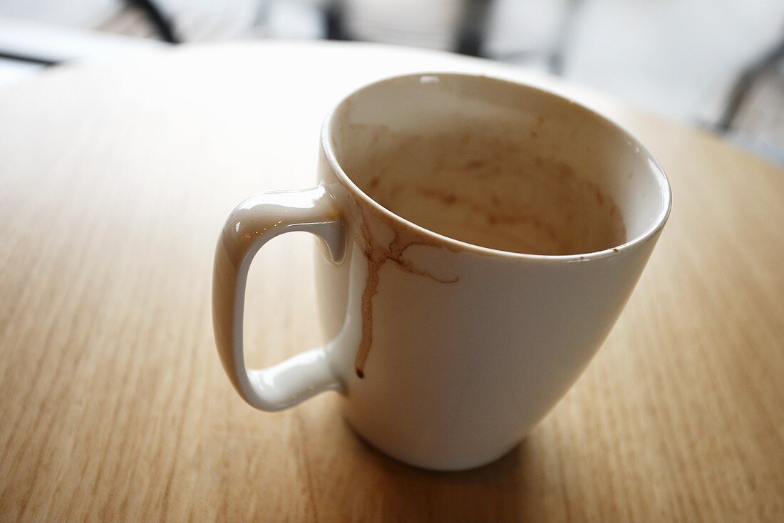 Tasse mit ausgetrunkenem Kakao auf Tisch im Restaurant