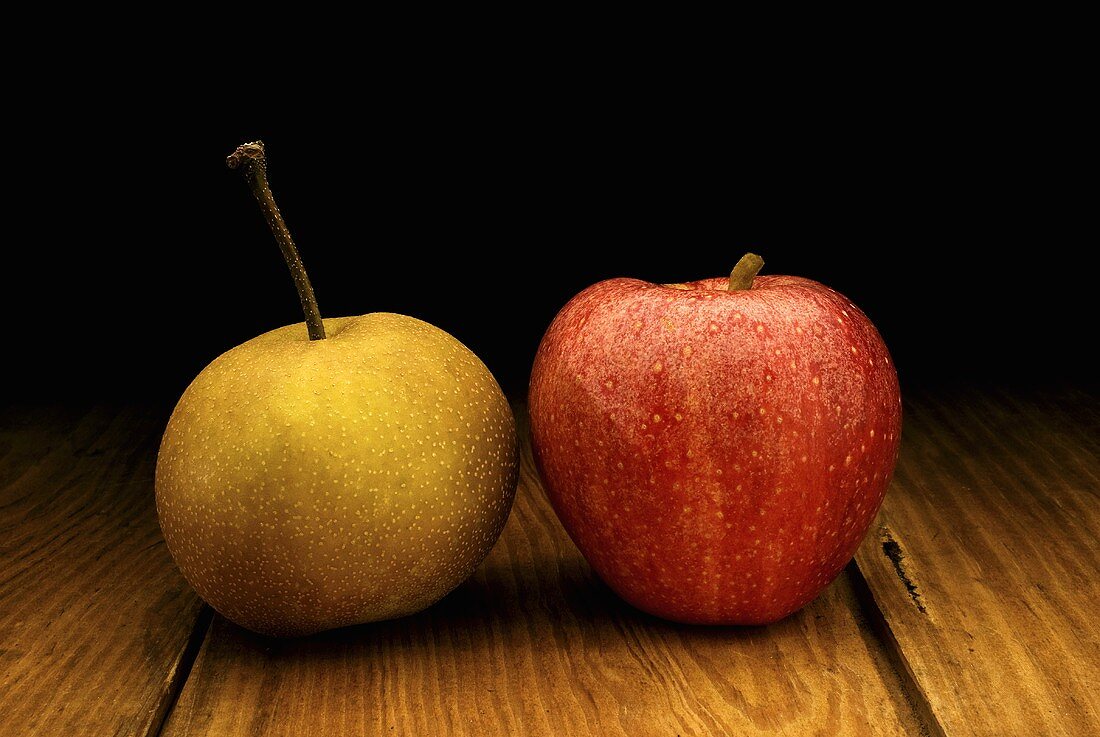 Nashibirne und Apfel auf Holztisch