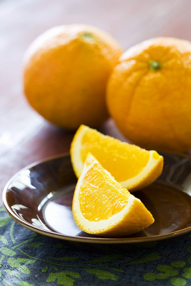 Two Naval Orange Wedges on a Plate; Whole Naval Oranges