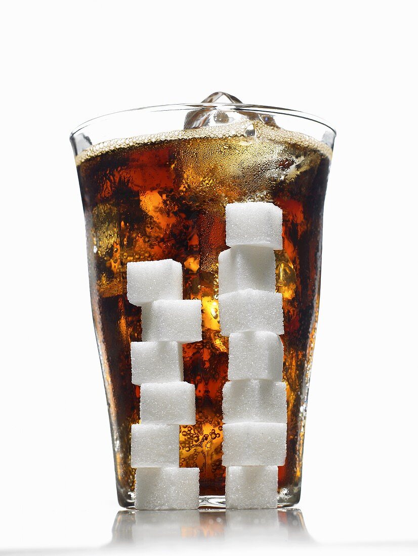 Glass of Cola with Ice; Stacked Sugar Cubes In Front of Glass; White Background