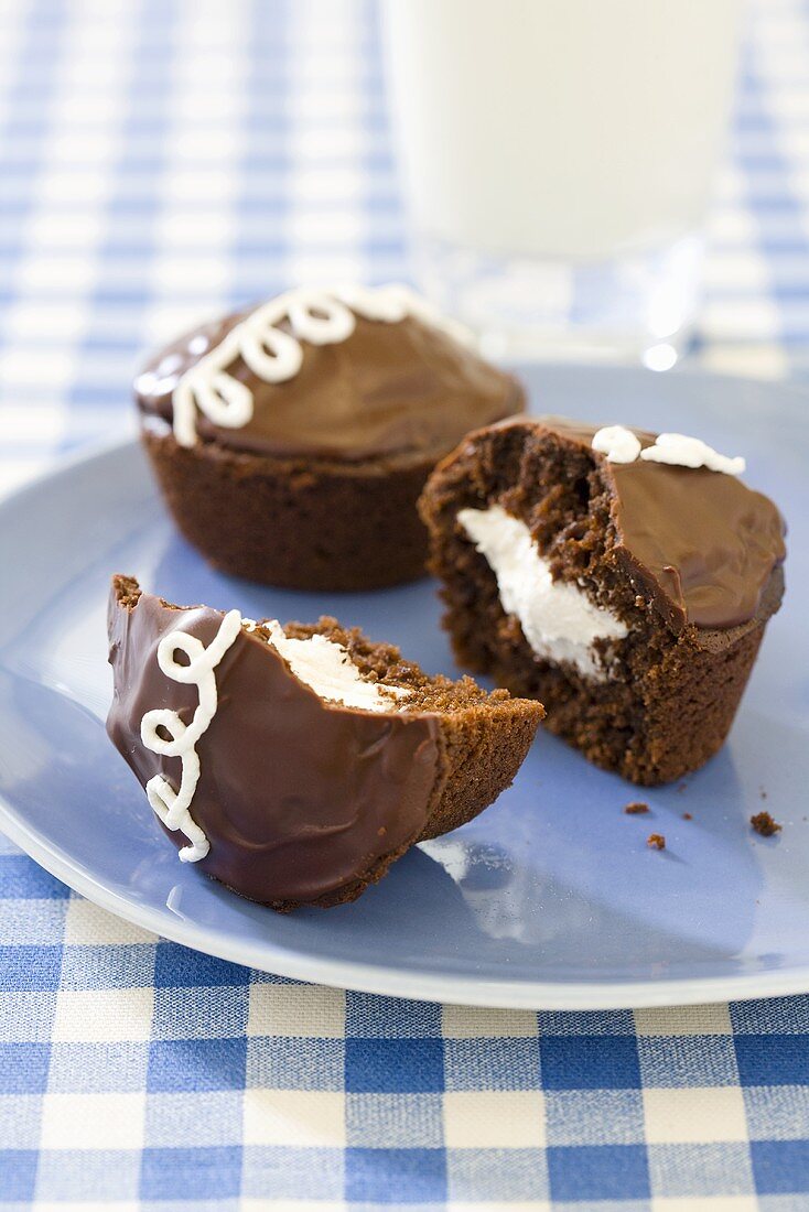 Cream Filled Chocolate Cupcakes; On Plate; Glass of Milk