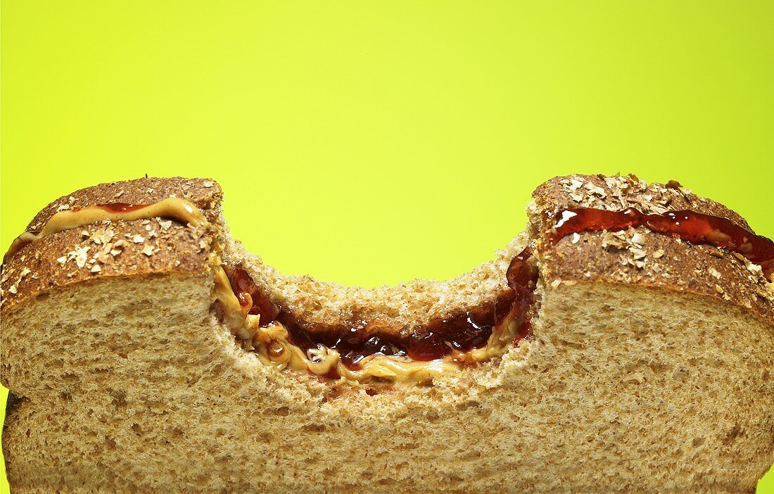 Peanut Butter and Jelly Sandwich on Wheat Bread with Bite Taken Out