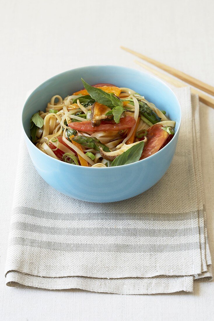 Bowl of Asian Noodles with Veggies and Basil; Chopsticks