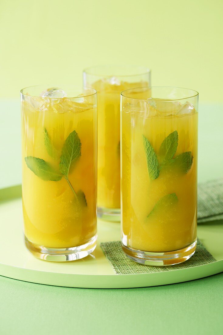 Three Tall Glasses of Mango Coolers with Mint; On Tray
