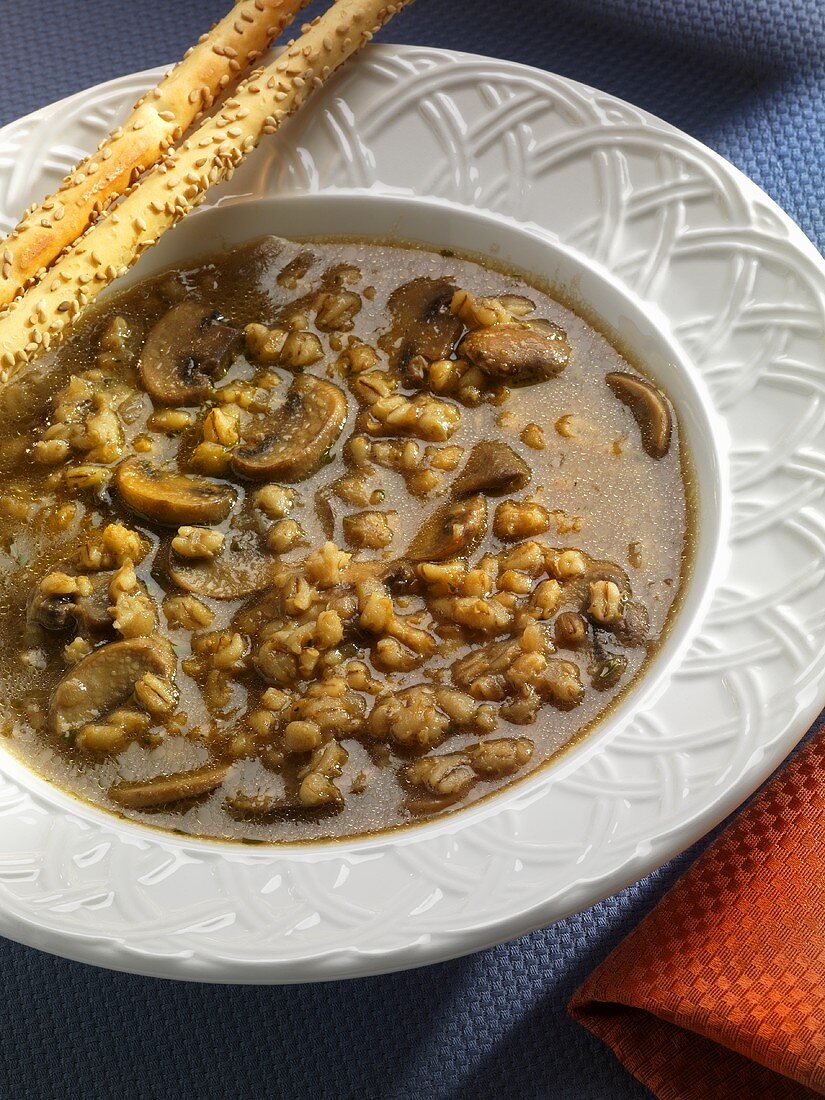 Bowl of Mushroom Barley Soup with Bread Sticks