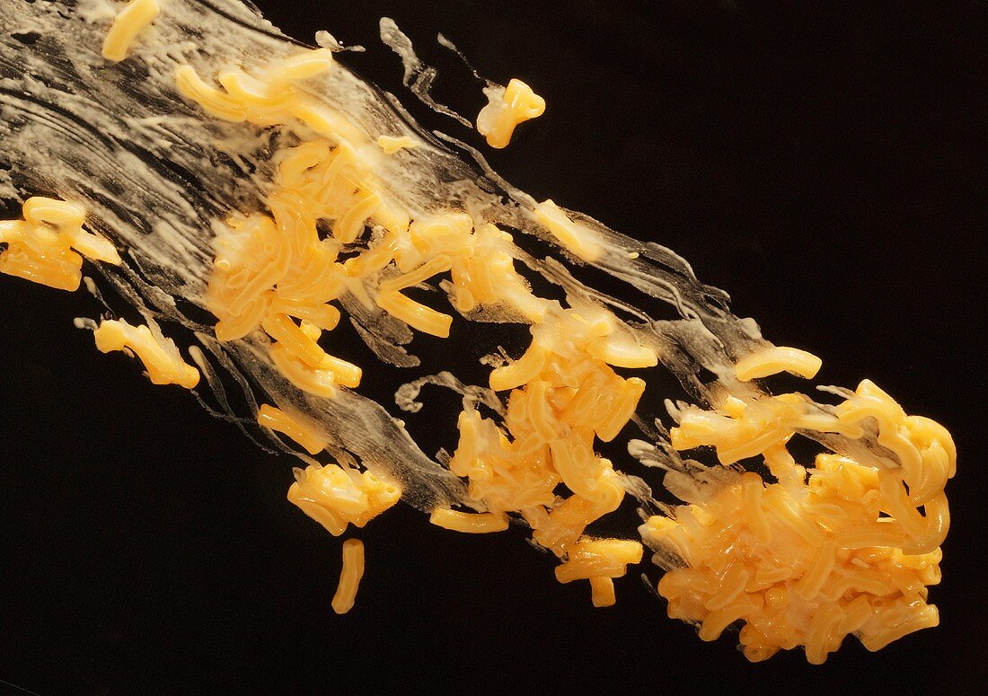 Macaroni and Cheese Sliding Across a Black Background
