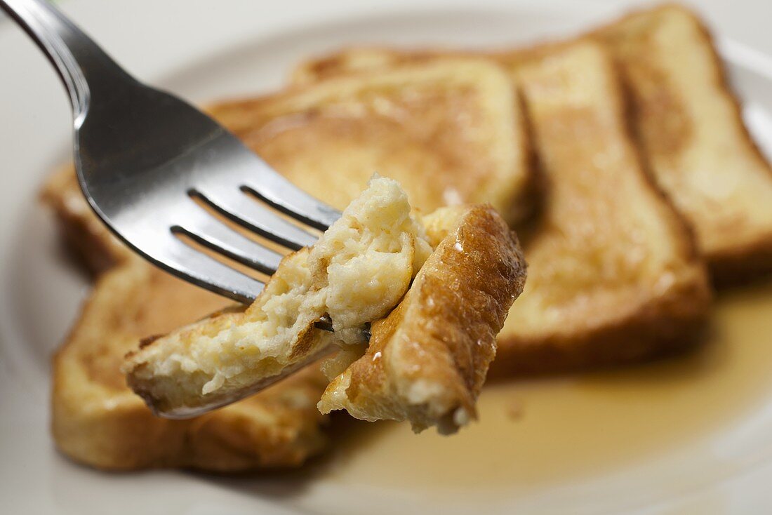 French Toasts mit Ahornsirup auf Gabel und Teller