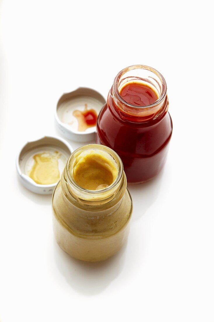 Open Jar of Mustard and Open Jar of Ketchup; From Above; White Background