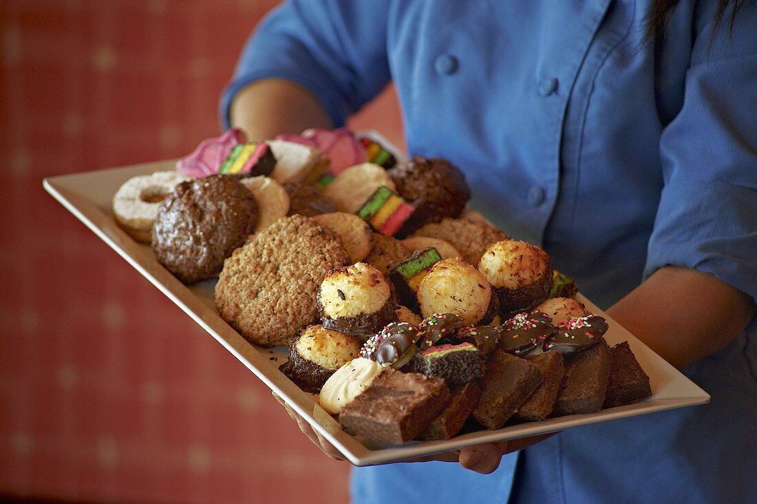 Chef Carrying a Large Platter of Assorted Custom Made Cookies and Pastries