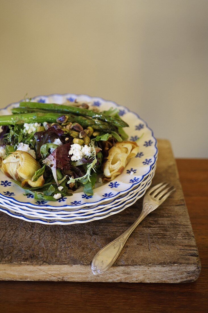 A mixed leaf salad with fried artichokes, asparagus, goat's cheese and pistachios