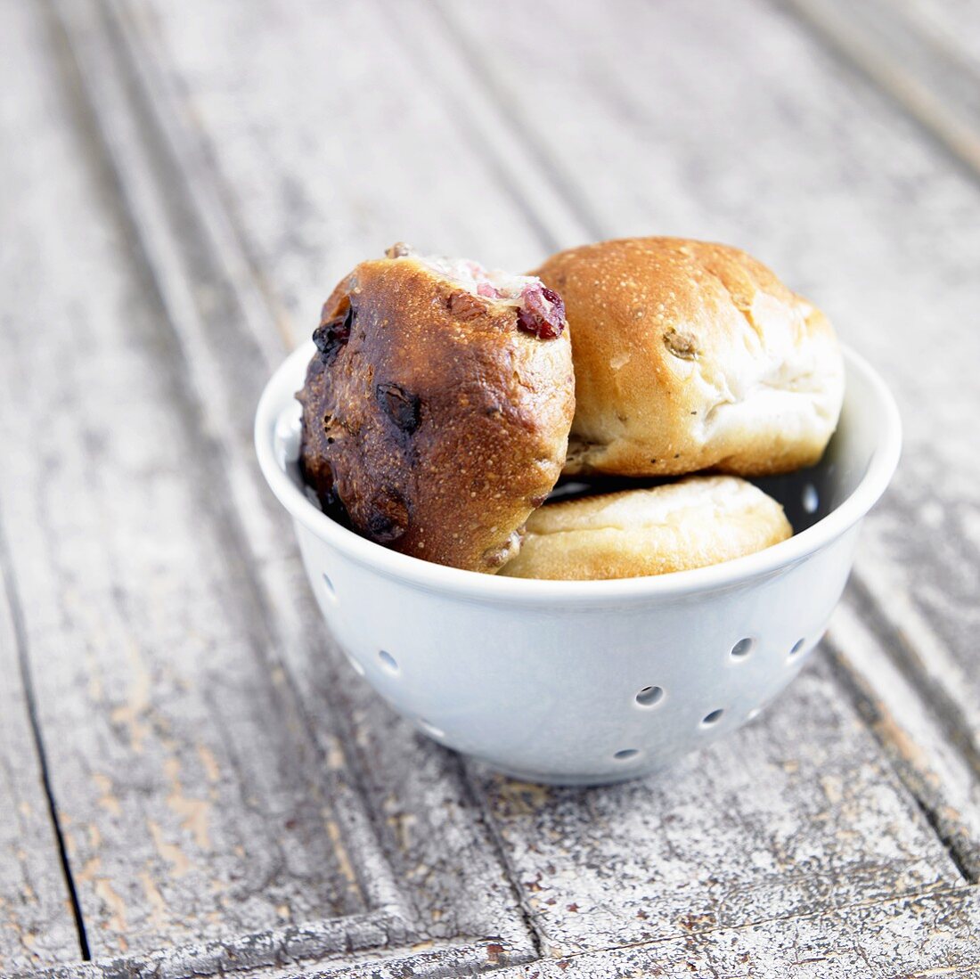 Milchbrötchen mit Rosinen in kleinem Sieb