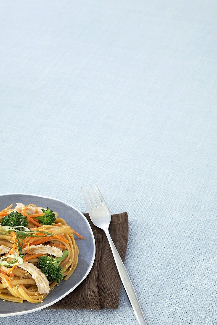 Chicken Broccoli Over Asian Noodles; Brown Napkin and Fork