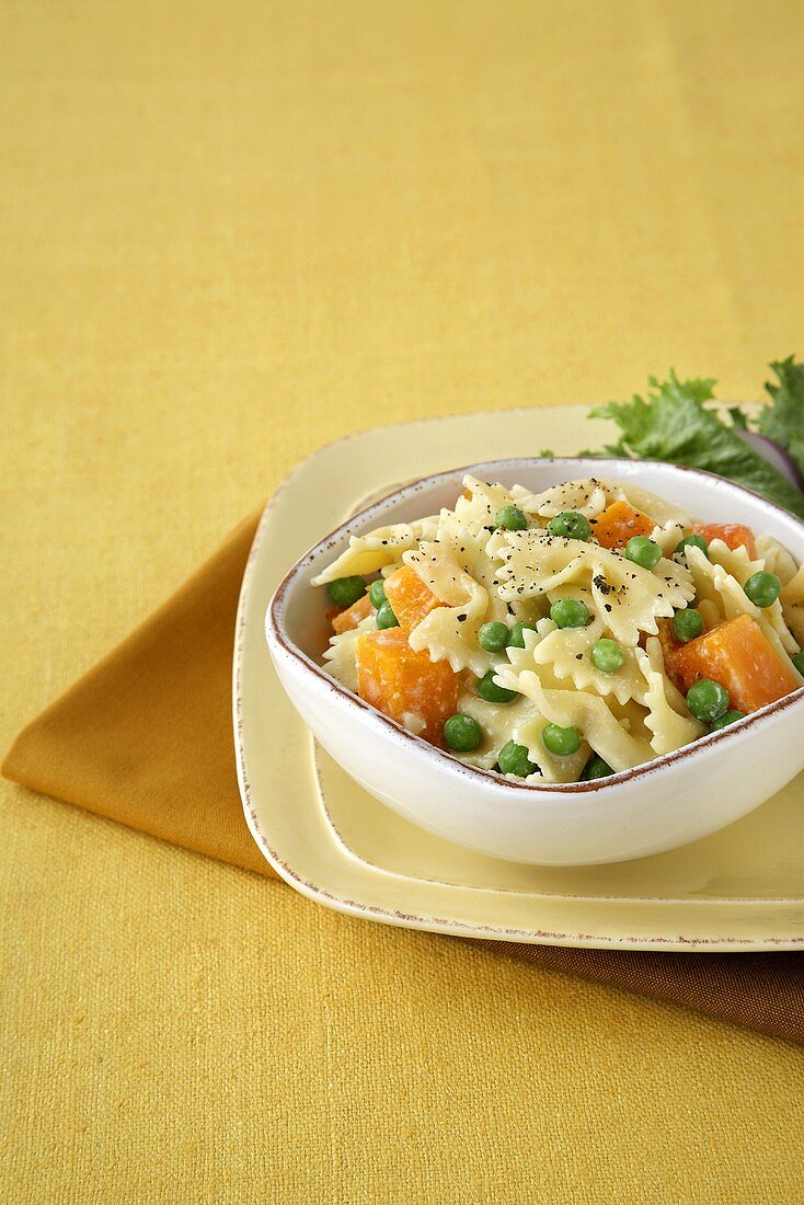 Farfalle Pasta with Peas and Squash in a Bowl; Side Salad