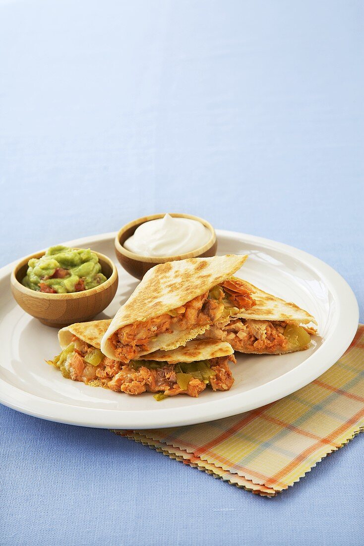Salmon and Cheese Quesadillas on a Plate with Sour Cream and Guacamole