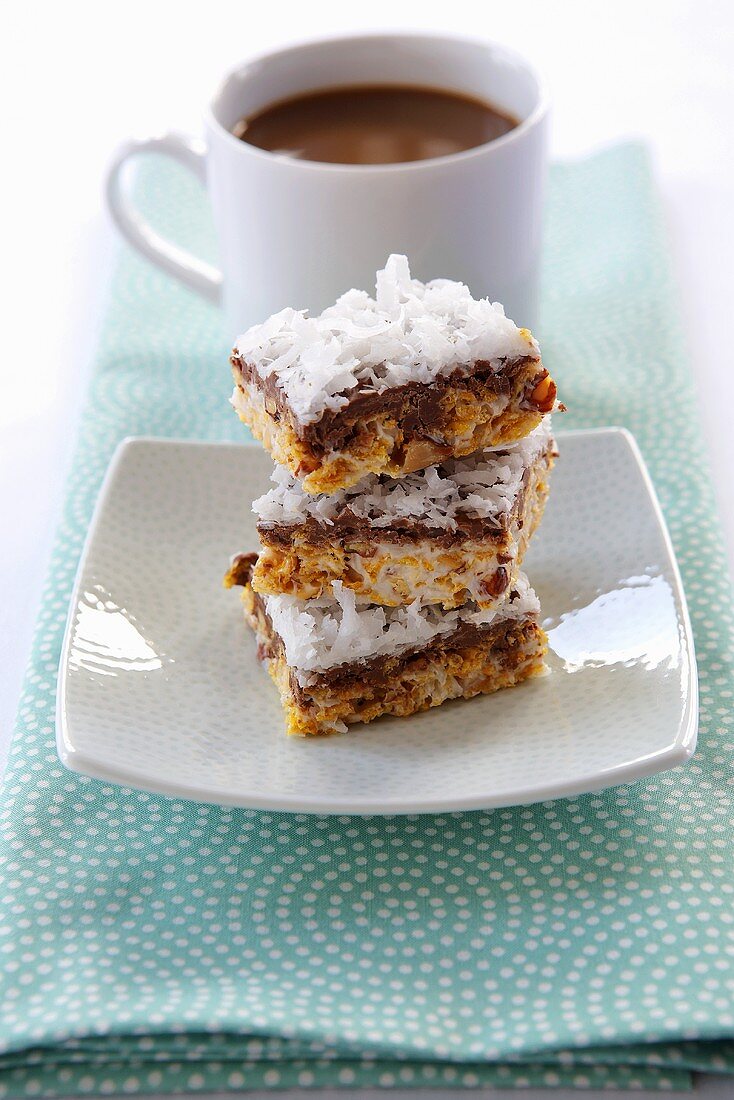 Three Almond Chocolate Coconut Bars; Stacked; Cup of Coffee
