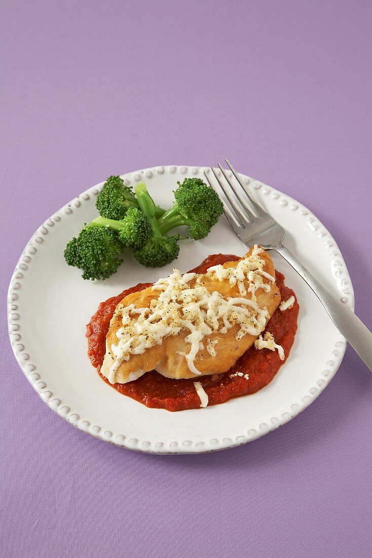 Chicken Parmesan with Broccoli on a White Plate; From Above