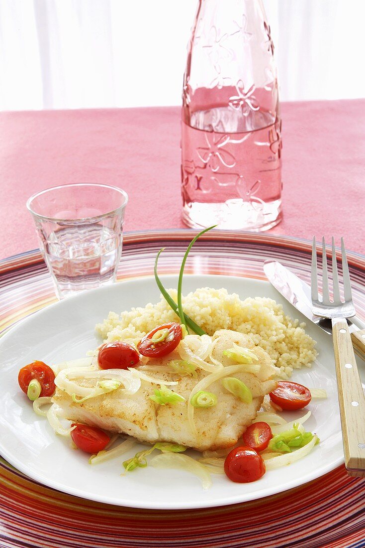 Cod with Cherry Tomatoes and Rice on a Plate; Knife and Fork