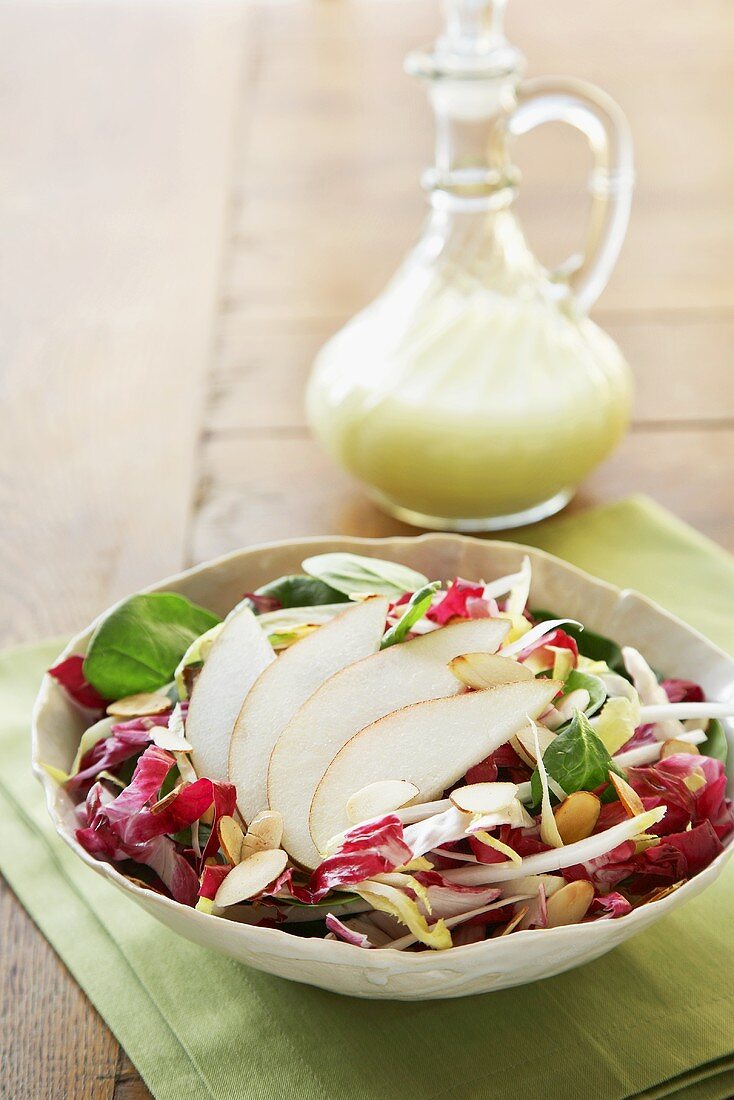 Bowl of Pear Salad with a Small Pitcher of Dressing