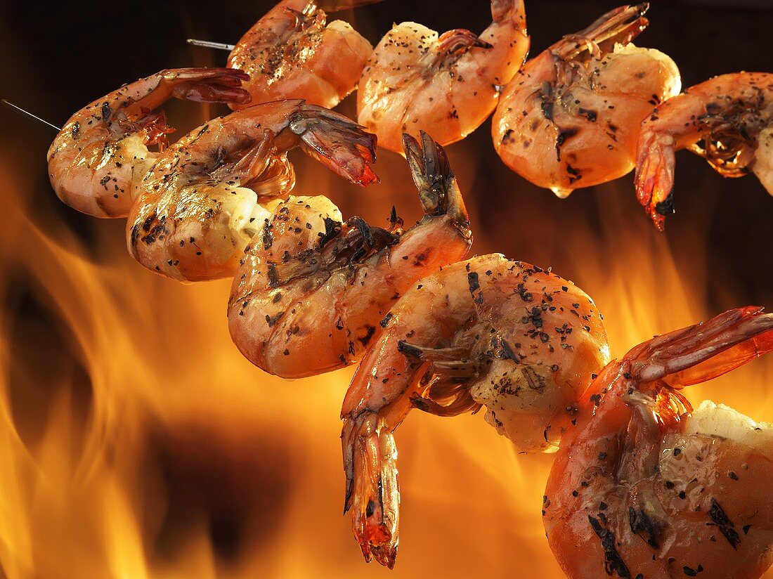 Two Skewers of Seasoned Shrimp Over an Open Flame