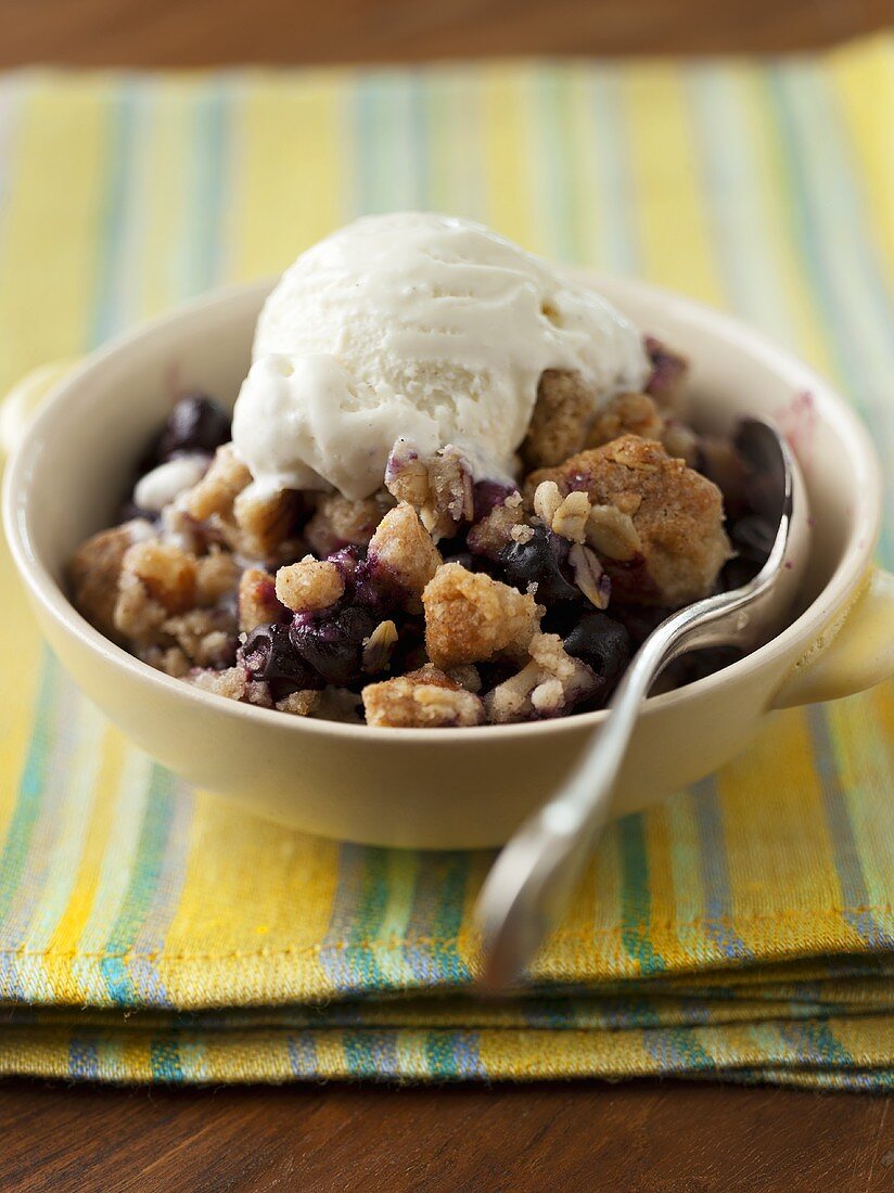 Blueberry Cobbler with a Scoop of Vanilla Ice Cream in a Bowl; Spoon