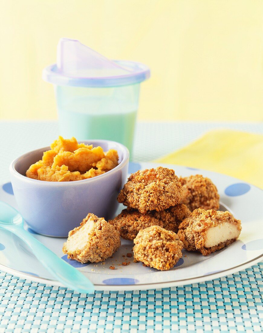 Chicken nuggets with mashed sweet potatoes and a cup of milk