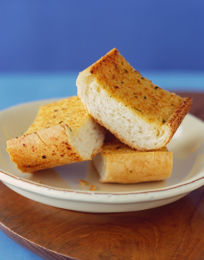 Three Pieces of Garlic Bread on a Small Plate
