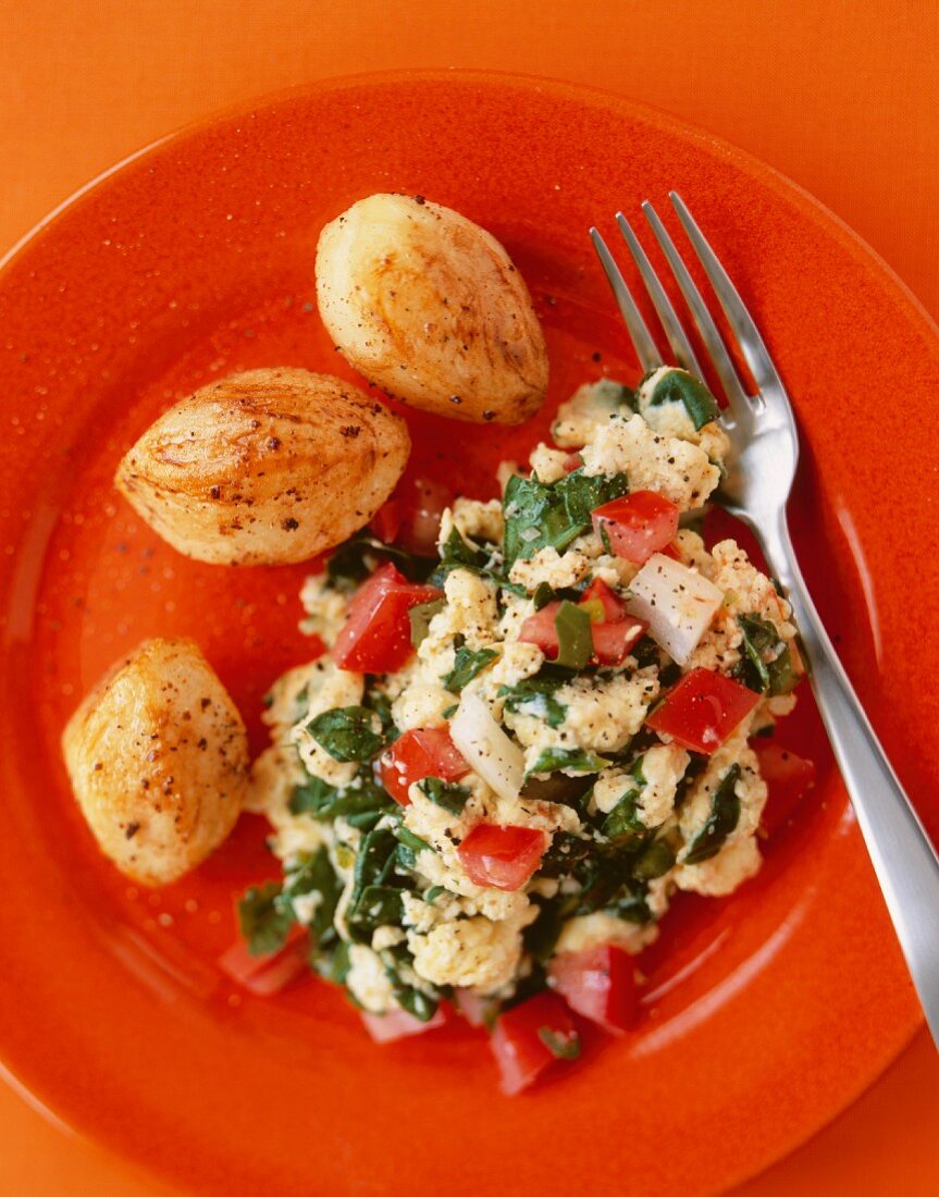Spinach Ricotta Scrambled Eggs with Tomato; On a Red Plate; From Above