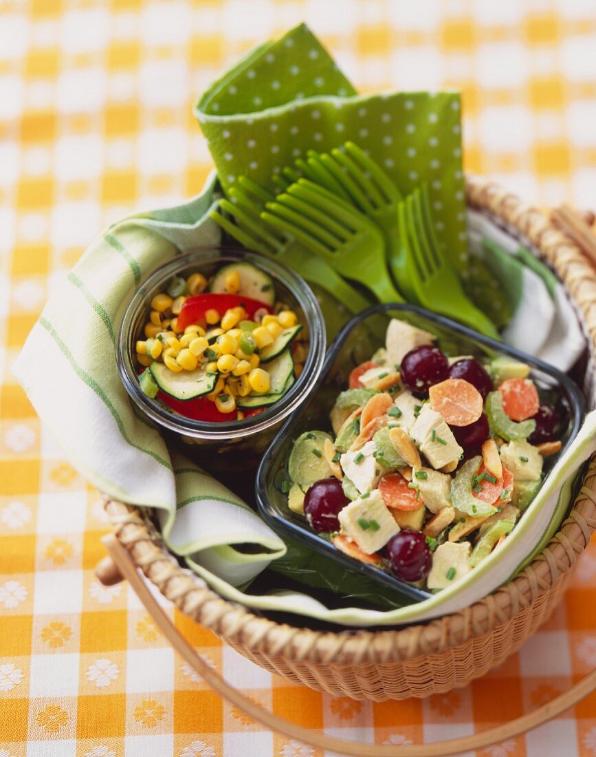 Picknickkorb mit Hähnchensalat und Mais-Zucchini-Salat