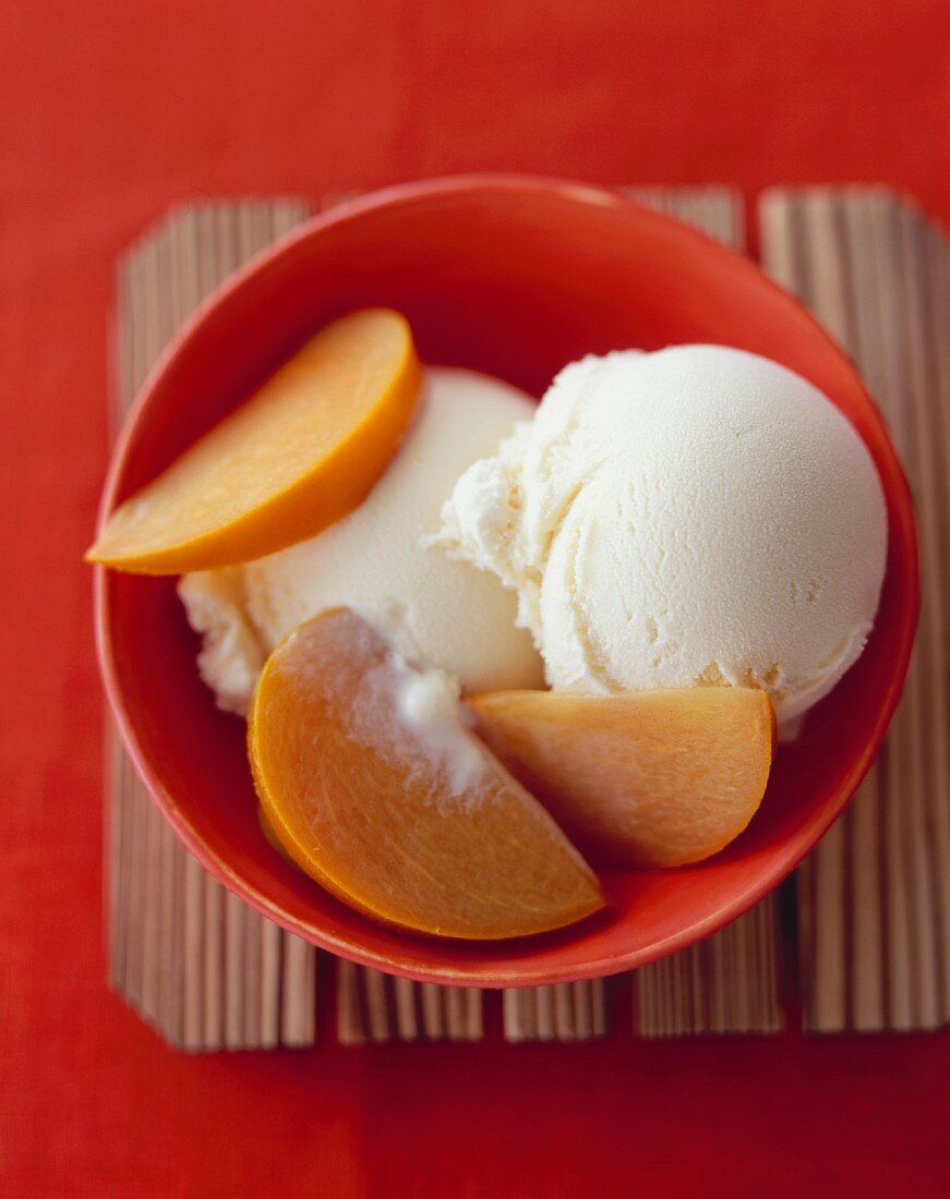 Sliced Persimmon Over Vanilla Ice Cream; In a Bowl; From Above