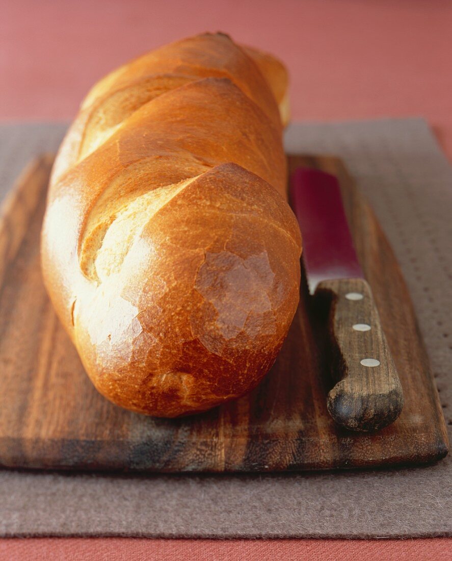 Loaf of French Bread on a Cutting Board with a Knife