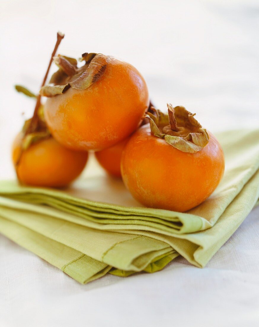 Persimmons on Folded Green Linen
