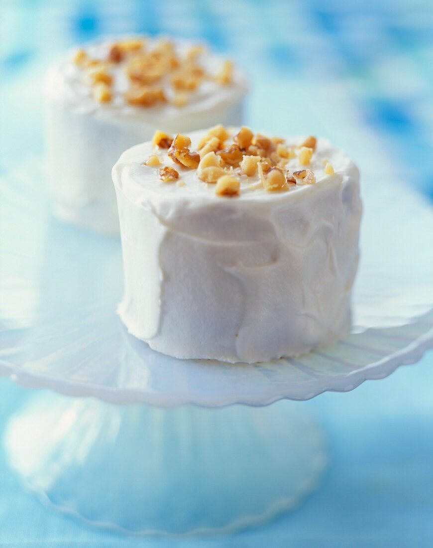 Mini-Möhrenkuchen mit weißem Zuckerguss und gehackten Nüssen