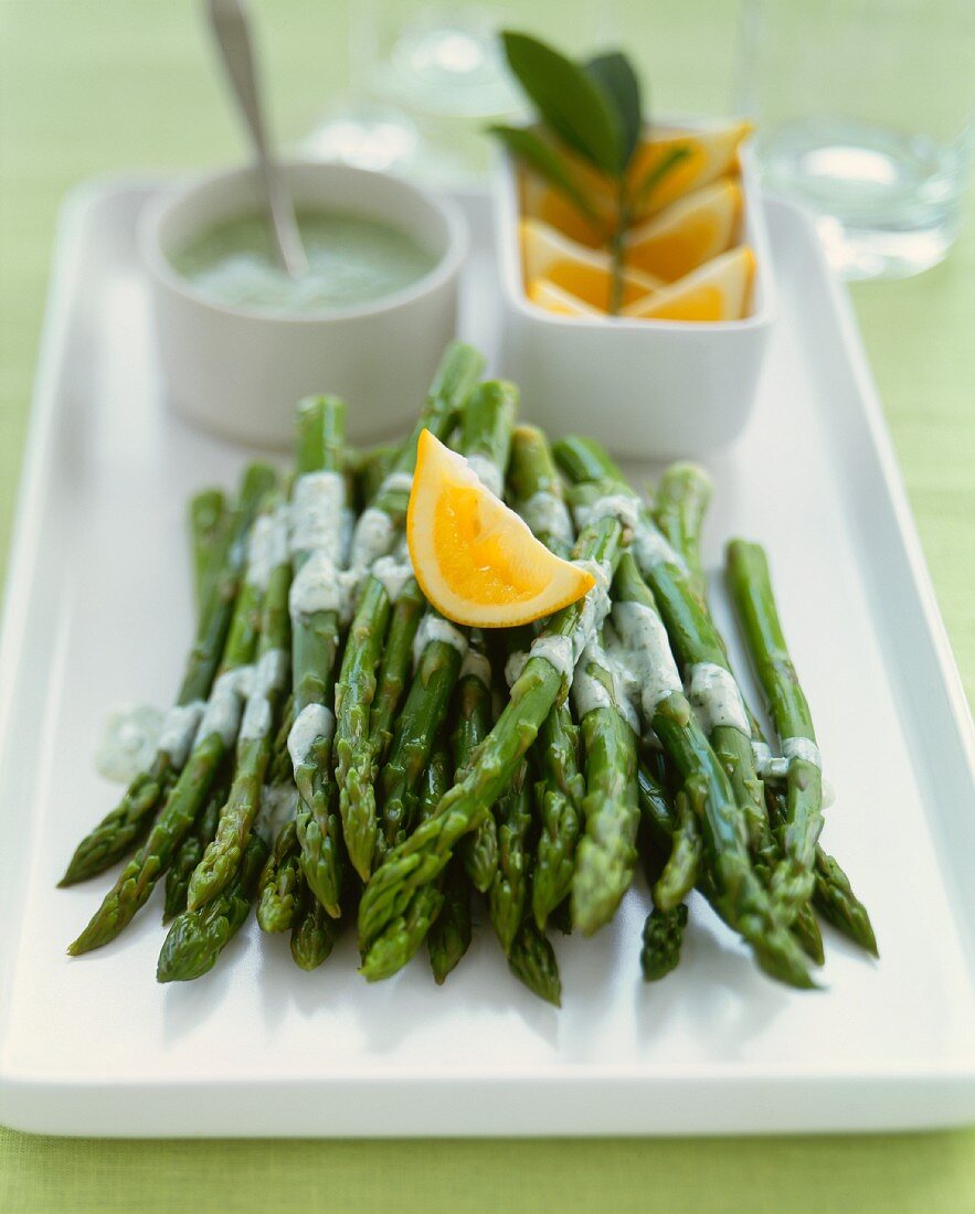 Asparagus Spears with Herb Sauce and an Orange Wedge