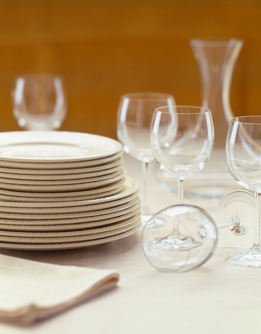 Stacked White Plates and Empty Stem Glasses