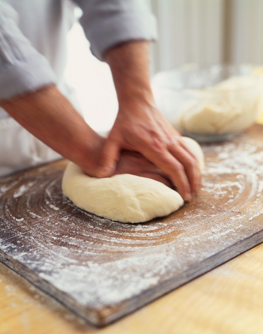 Man Kneading Dough on a Floured Surface