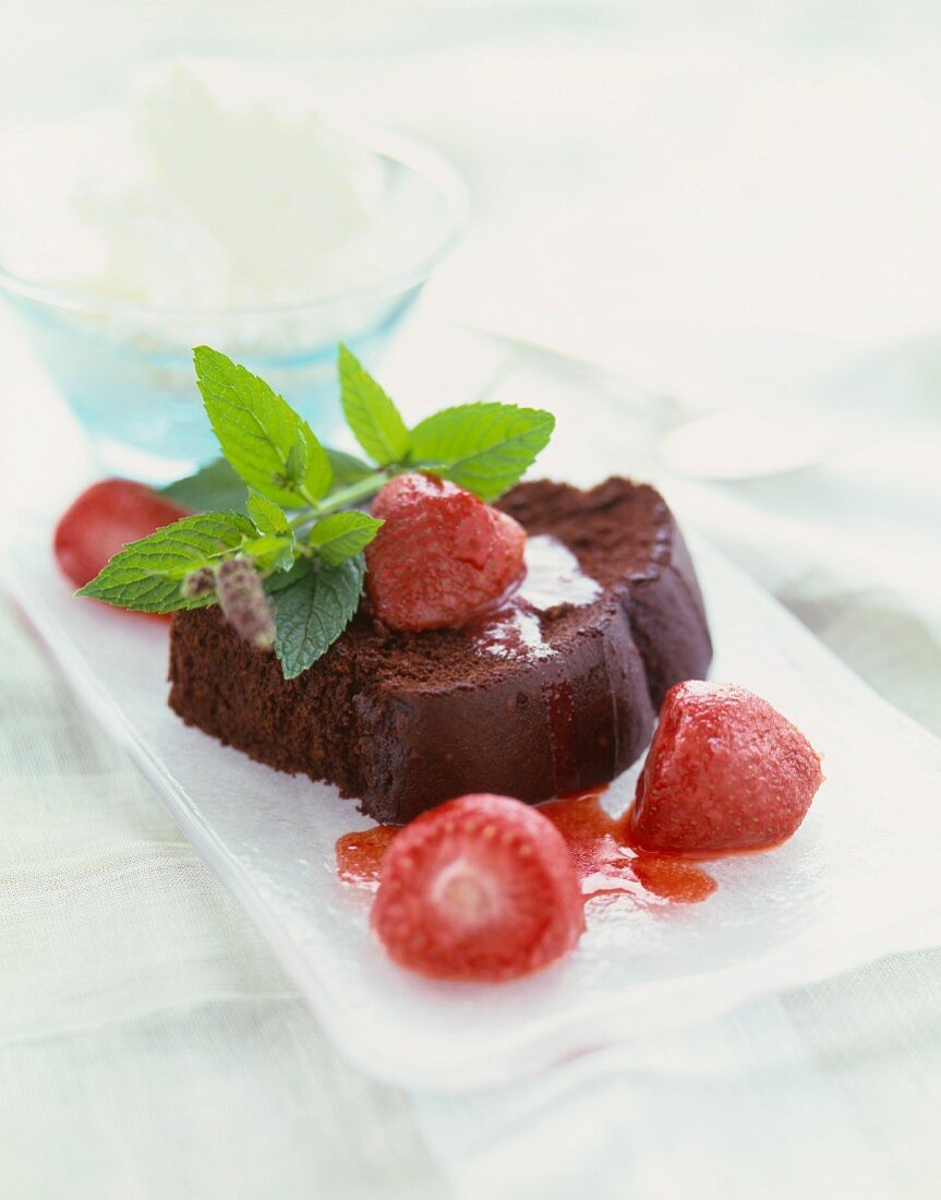Ein Stück Schokoladenkuchen mit Erdbeeren und Minze