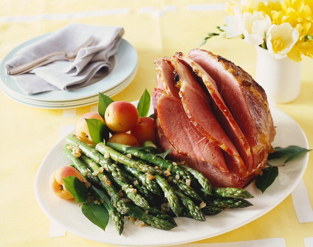 Glazed roast ham with green asparagus and apricots