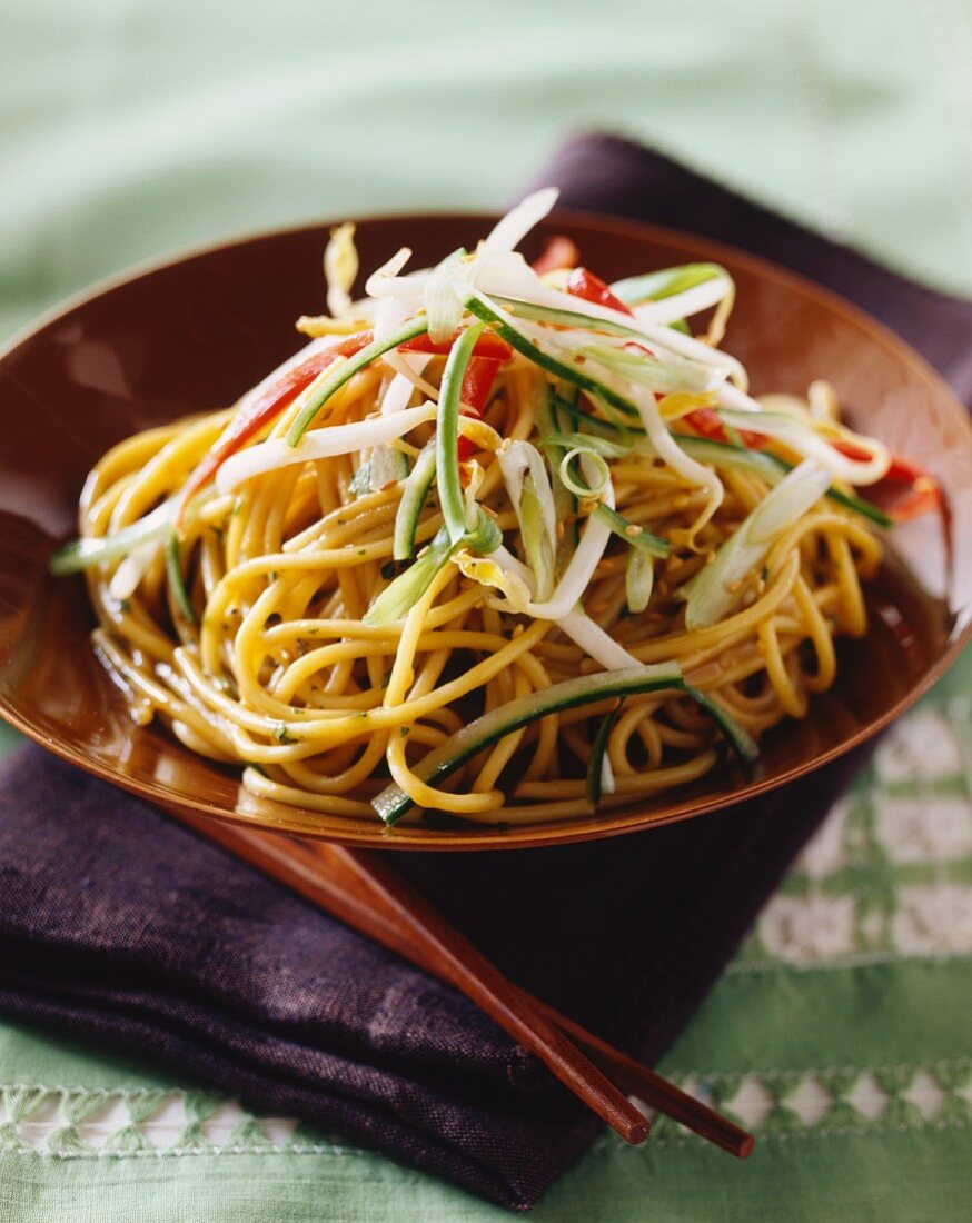 Egg noodles with pepper strips, courgette, sprouts and sesame seed oil (Asia)