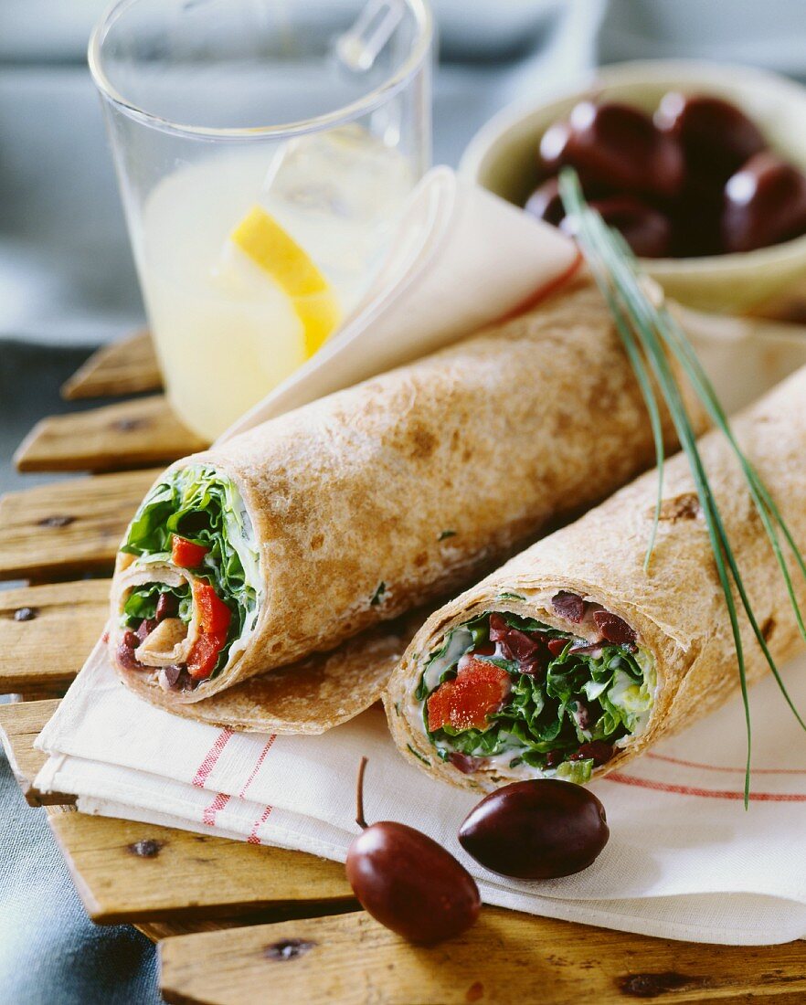 Salad and olive wraps and a glass of lemonade