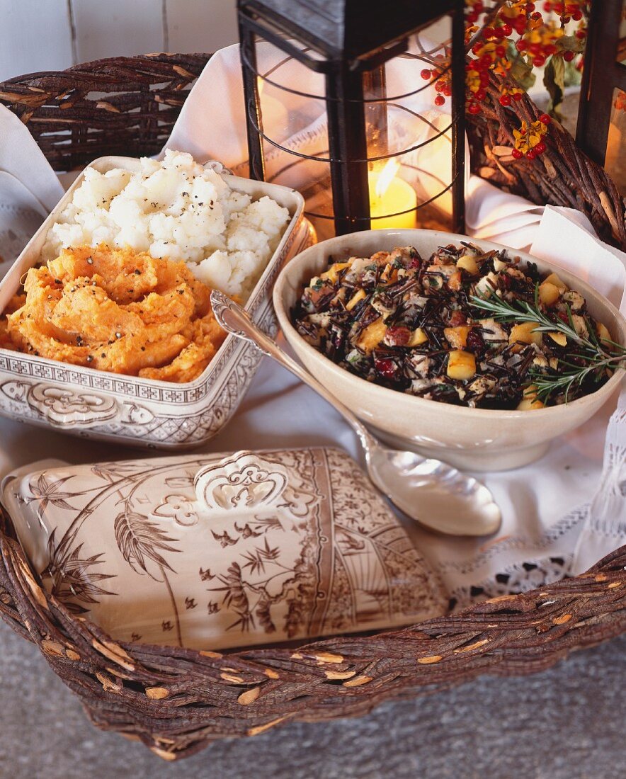 Side dishes for Thanksgiving: wild rice stuffing, mashed potatoes and mashed sweet potatoes (USA)