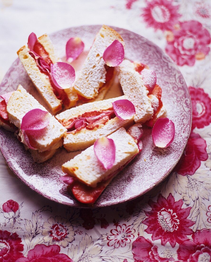 Süsse Erdbeersandwiches mit Rosenblättern und Puderzucker