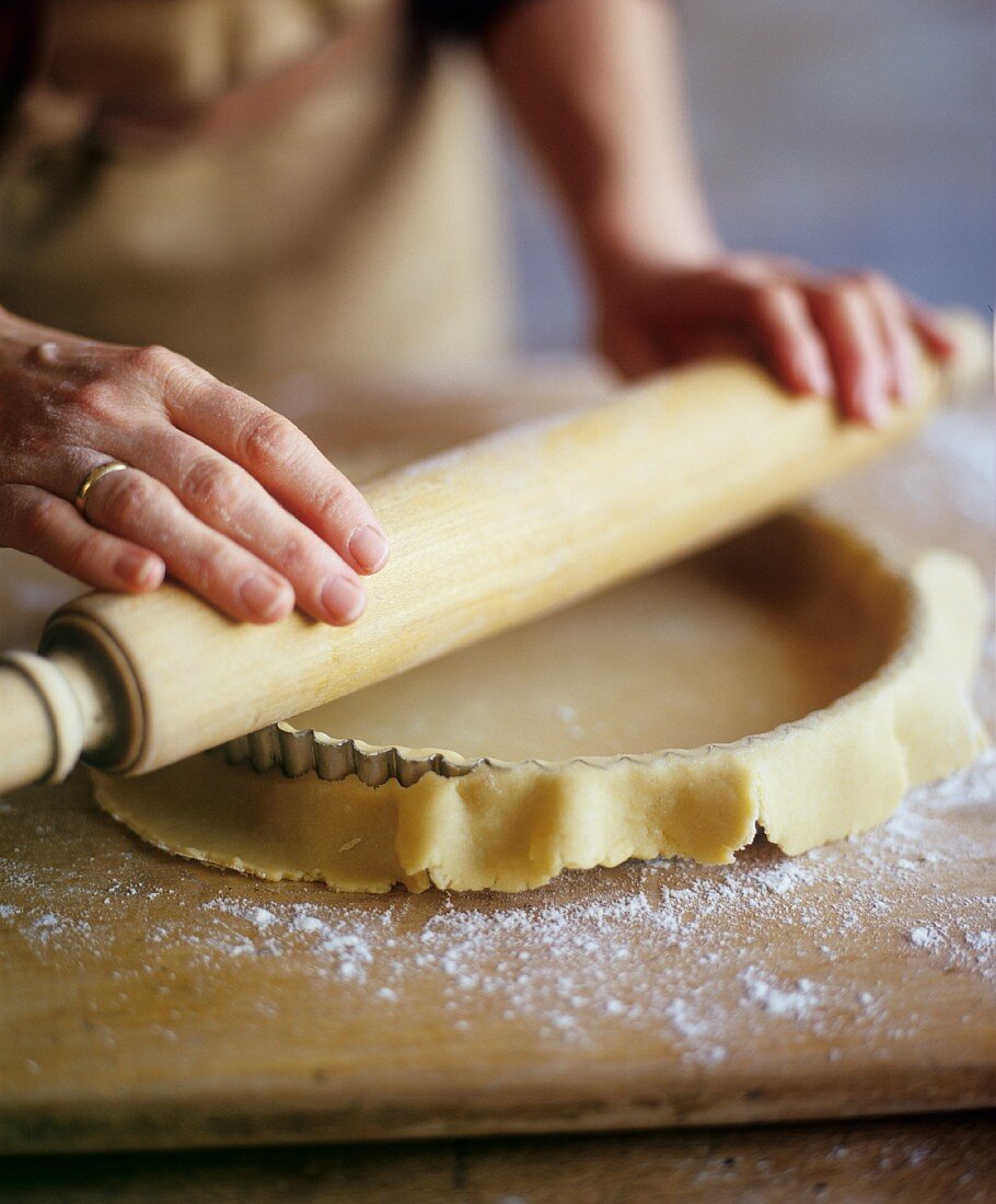 Shortcrust pastry being placed in a tart dish