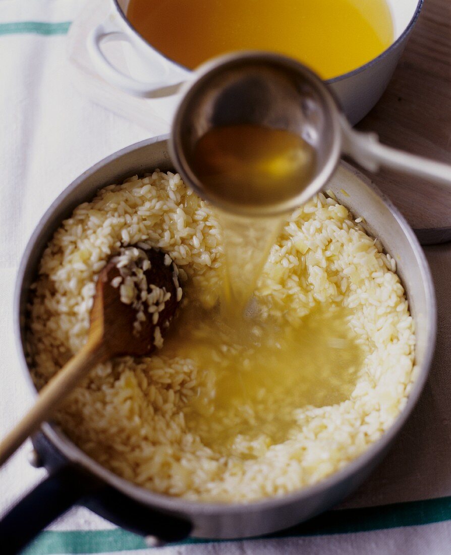 Adding Broth to Arborio Rice for Risotto